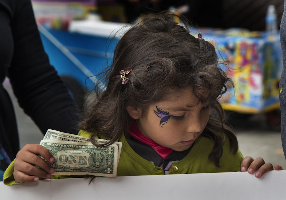 A child buys tickets at the Halloween-Día de los Muertos fundraiser for Junipero Serra Elementary in Bernal Heights. The event netted $3,000 for the PTA. Photo by Tearsa Joy Hammock / San Francisco Public Press