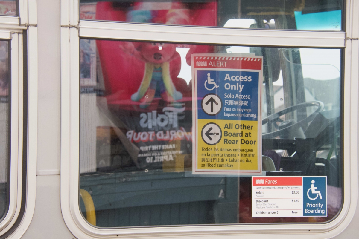 A sign in the window of a 14 Mission bus, one of the few Muni routes still running on April 8, asks riders to board through the rear door to keep social distance from the driver.