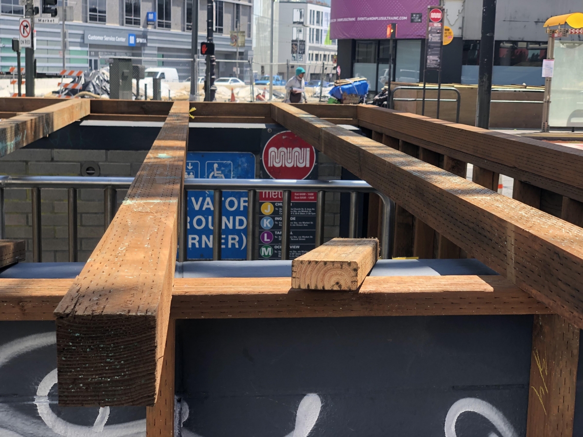 Workers started boarding up an entrance to the Van Ness Muni stop on April 10. Muni headquarters is within view across Market Street. In response to the pandemic, Muni stopped running all underground trains and replaced them with buses.