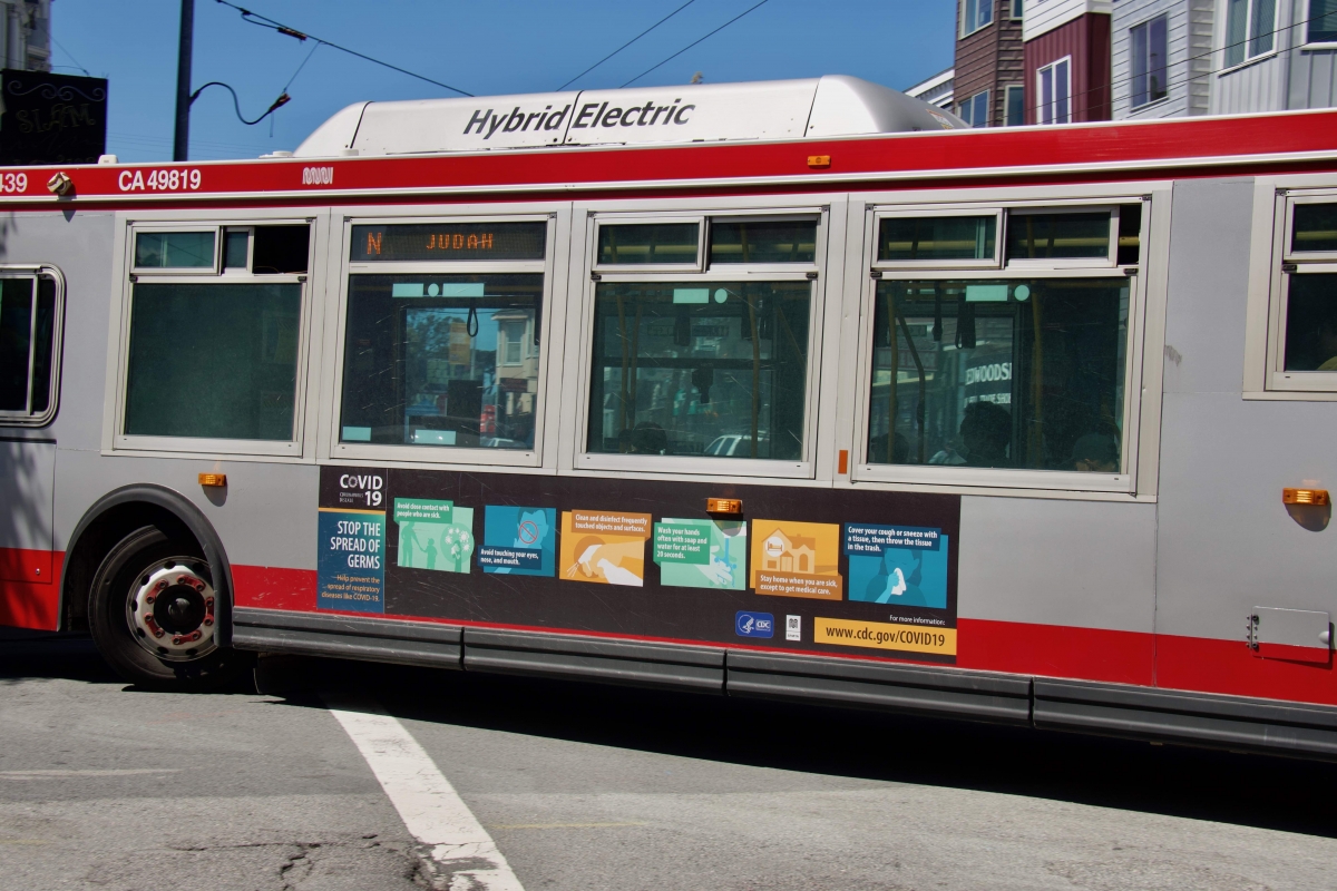 An N Judah bus with a CDC coronavirus public service announcement on the side turns off Haight Street on April 7. The 6 and 7 buses, which typically ran on Haight Street, were cut because of the coronavirus pandemic.