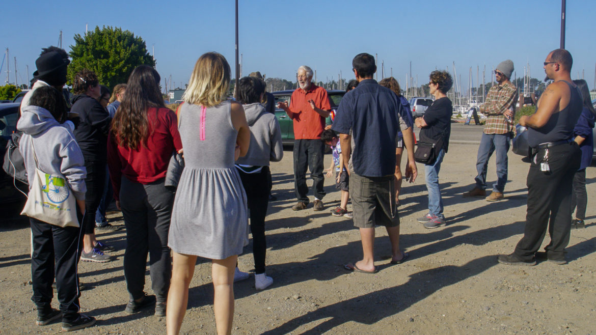 On Memorial Day in 2018, civil rights attorney Osha Neuman explains to vehicle residents at the Berkeley Marina that their efforts to negotiate for a sanctioned place to park there have failed, and they have to move or risk being towed. Waterfront staff posted construction notices on the meadow lot, forcing dozens of vehicle dwellers to relocate to other parts of the city.