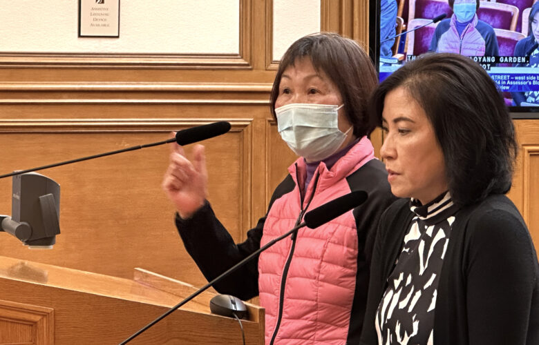 At a City Hall meeting in San Francisco, an interpreter helps a resident make a public comment.