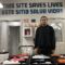 A man wearing dark clothing stands behind a table with syringes and trays of other medical supplies. The words "THIS SITE SAVES LIVES" above "ESTE SITIO SALVA VIDAS" are painted in blue in large letters high on the wall behind him.