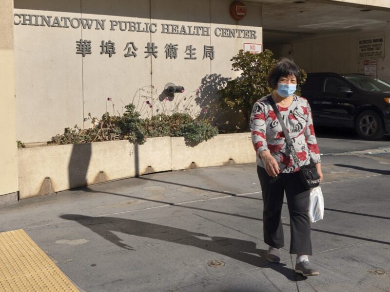 A woman walks out of the Chinatown Public Health Center.