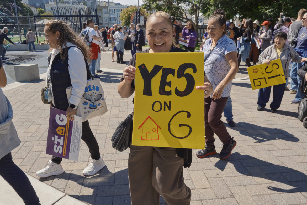 A rally attendee holds a sign that reads “Yes on G.”