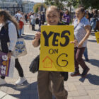 A rally attendee holds a sign that reads “Yes on G.”