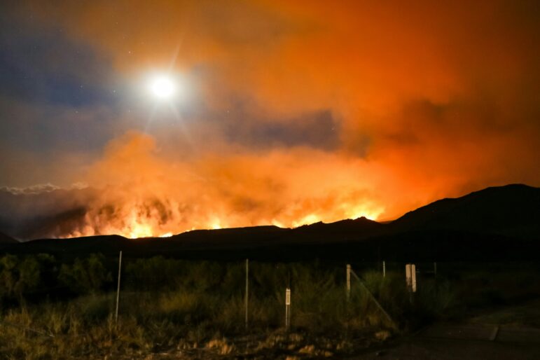 A wildfire rages in the distance, in California's Sierra Nevada mountains.