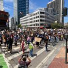 Throngs of people march through the intersection of Van Ness and Market Street, in San Francisco in 2020.