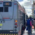 A group of people lined up trying to get on a bus